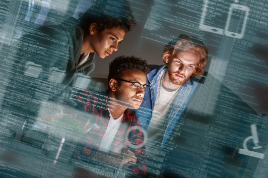 three technology professionals viewing computer screen with screenshot overlay